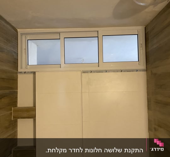 חלון אלומיניום עם מסגרת לבנה בחדר אמבטיה